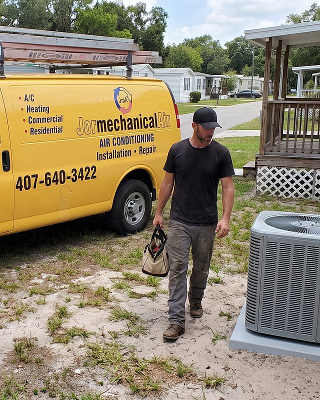 A technician with a tool bag beside the Jormechanical Air van and an outdoor AC unit