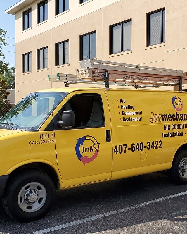 The yellow Jormechanical Air service van parked outside an office building